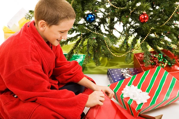 Chłopiec otwiera prezent — Zdjęcie stockowe