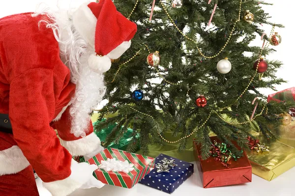 Papai Noel coloca presentes sob árvore — Fotografia de Stock