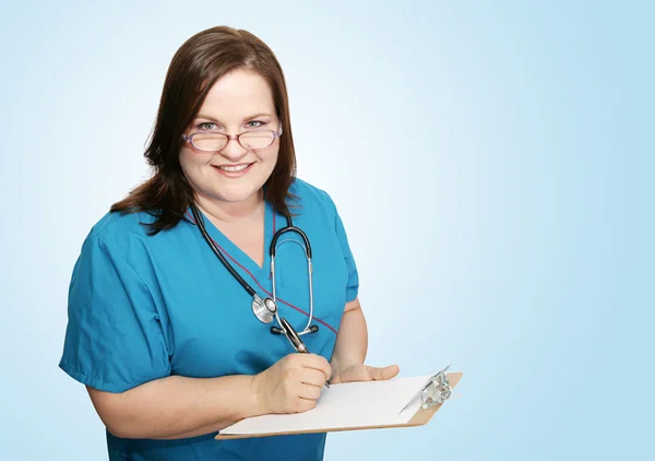 Verpleegster met Klembord op blauw — Stockfoto
