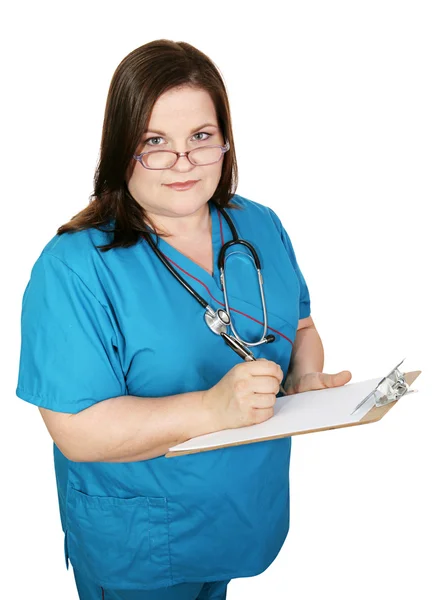 Серьезная медсестра делает заметки — стоковое фото