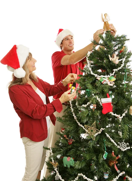 Filho ajuda a mãe a decorar árvore de Natal — Fotografia de Stock