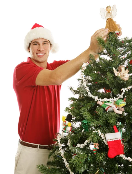 Junger Mann schmückt Weihnachtsbaum — Stockfoto