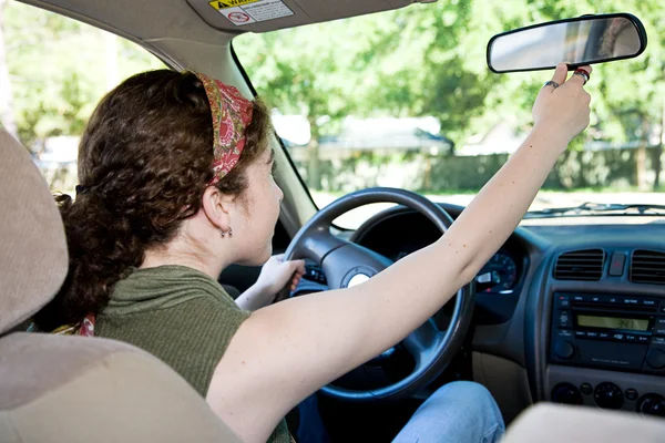 Подросток-водитель регулирует зеркало заднего вида — стоковое фото