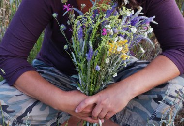 genç bir kadının nazik ellerini kır çiçekleri.