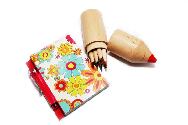 Blocco note con penna e matite colorate su sfondo bianco . — Foto Stock