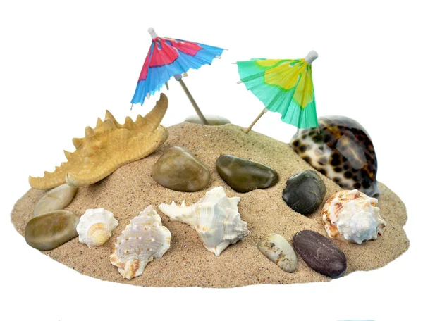 Пісок з парасолькою і черепашками — стокове фото