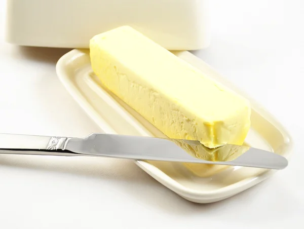 Máslo na bílé butterdish — Stock fotografie