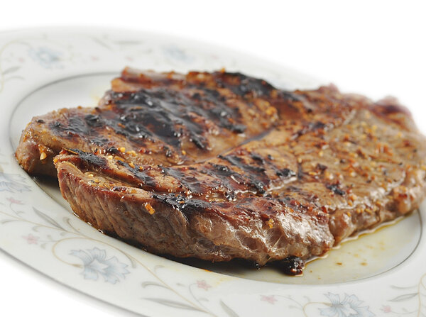 A fresh grilled steak on a plate ,close up