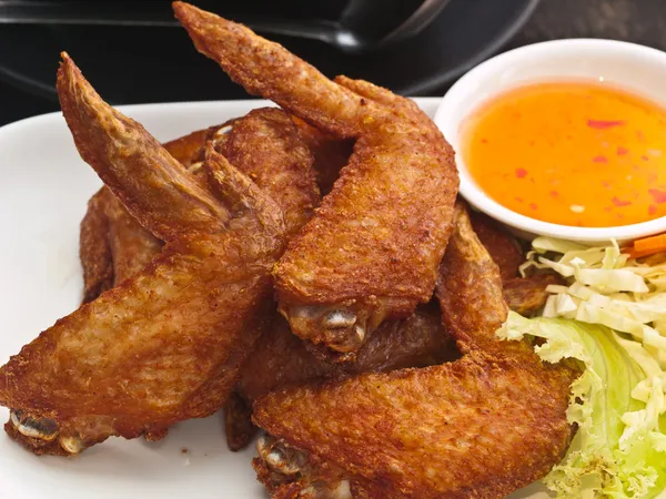 Крылышко жареного цыпленка на тарелке — стоковое фото