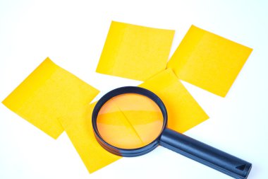 A magnifying glass hovering over the post-it Inspection clipart