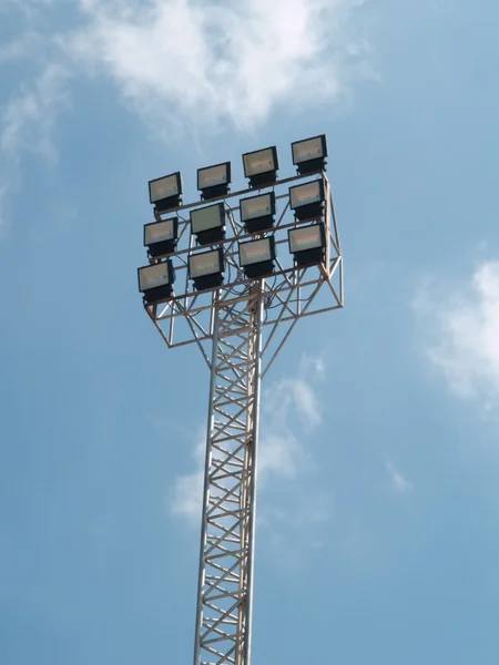 Flutlicht im Fußballstadion gegen blauen Himmel — Stockfoto