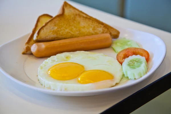 Жареные яйца, колбаса, тосты и овощи на белой тарелке — стоковое фото