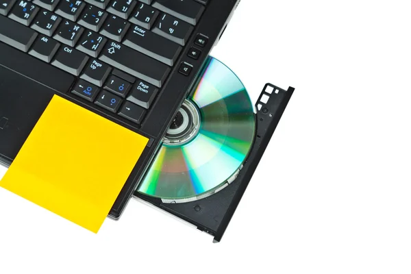 Close-up de um DVD em uma bandeja de laptop e post-it — Fotografia de Stock