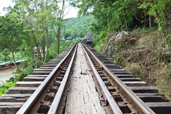 Trilhos de trem curva com uma floresta no fundo — Fotografia de Stock