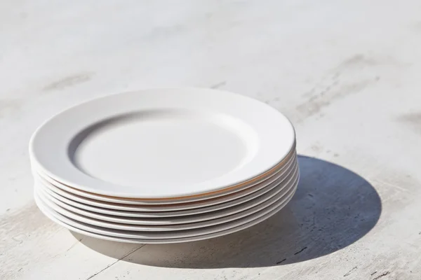 Montón de platos y sombra, sobre mesa de comedor —  Fotos de Stock