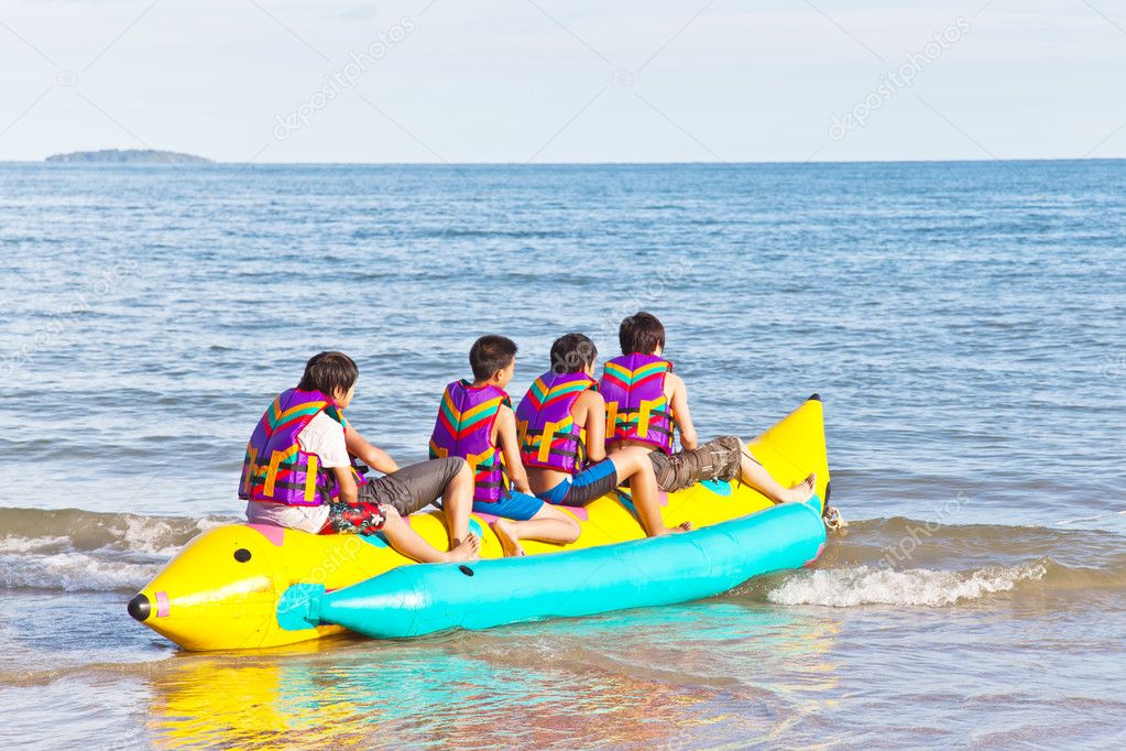 Group of young riding banana boat