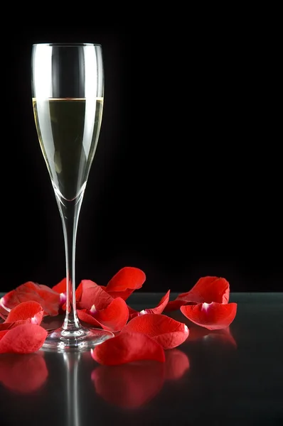 Bicchiere di champagne con petali di rosa — Foto Stock