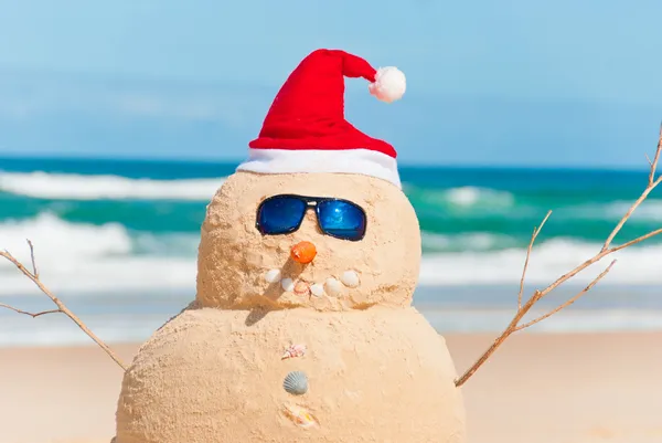 Schneemann aus Sand mit Weihnachtsmütze lizenzfreie Stockfotos
