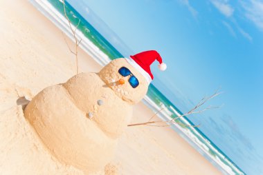 Snowman Built As Sandcastle On Beach clipart