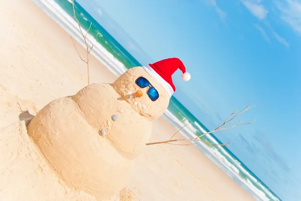 Boneco de neve construído como Sandcastle na praia Fotos De Bancos De Imagens