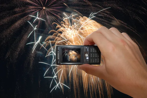 Telefone móvel com mão captura de fogos de artifício — Fotografia de Stock