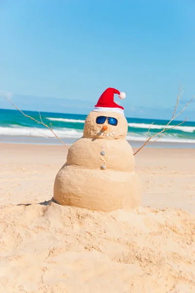 Жара и снеговик загорают на пляже — стоковое фото