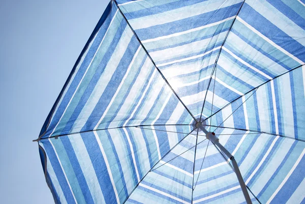 stock image Blue Backlit Parasol Against Plain Sky