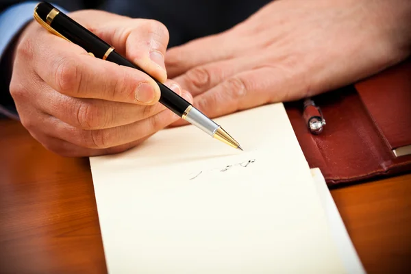 Closeup των χεριών ενός επιχειρηματία γράφοντας ορισμένα έγγραφα — Φωτογραφία Αρχείου