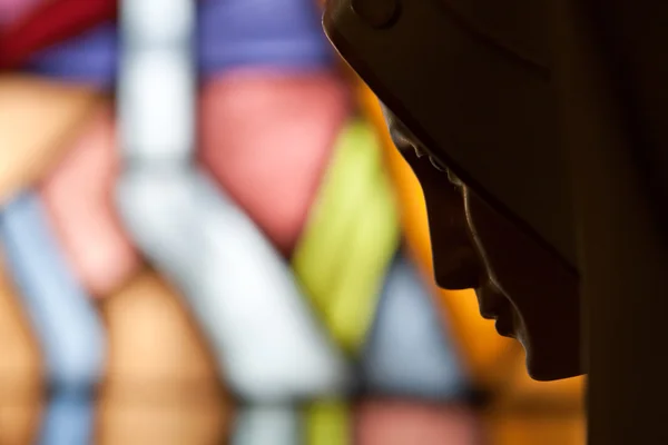 stock image Statue of holy mary on background stained glass