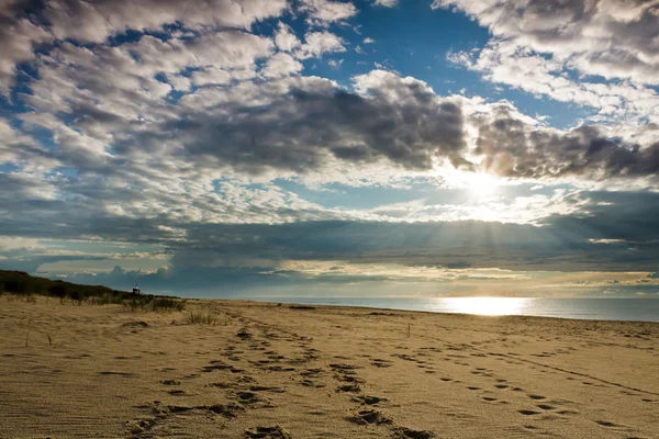 stock image Footsteps on sand and dynamic sky over baltic sea