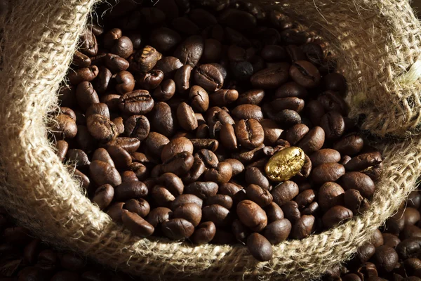 Semi di caffè dorato su sacchetto di caffè iuta — Foto Stock