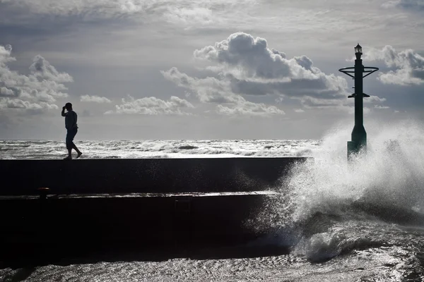 Silueta turística en groyne con gran ola —  Fotos de Stock