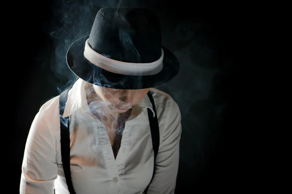 Optimistiskt kvinna med svart hatt i rök under täcke — Stockfoto