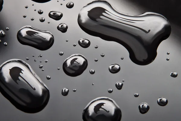 水滴の黒の背景に傘の形をしました。 — ストック写真