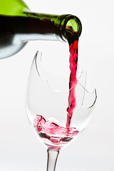 Red wine pouring to the broken glass — Stock Photo, Image