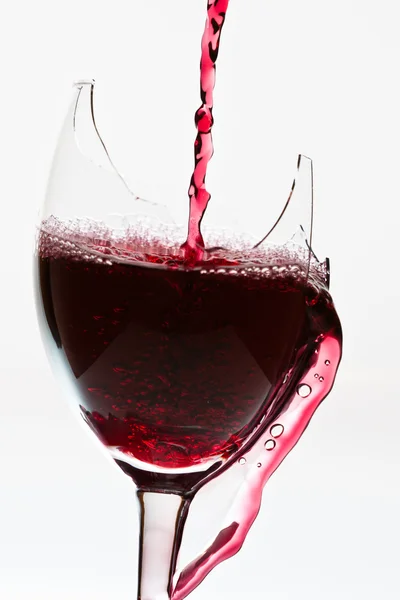Красное вино в разбитом бокале — стоковое фото