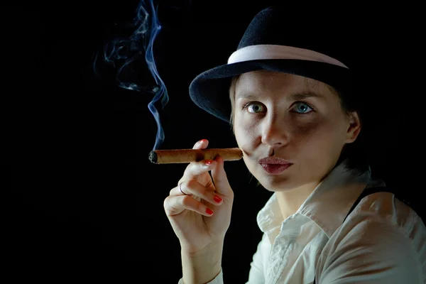 Woman in black hat with smoking cigar black background isolated — Stock Photo, Image