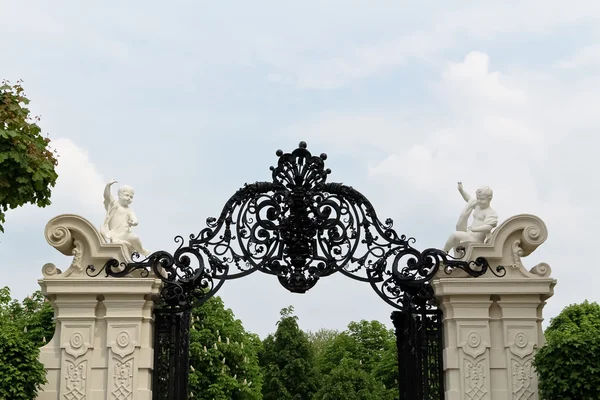 Iron gate flanked by angels — Stockfoto