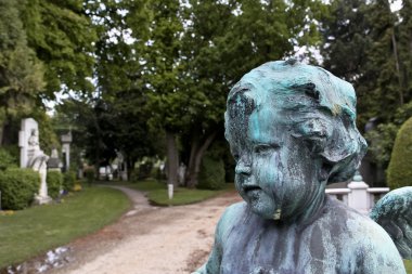 Baby angel at the entrance to a cemetery clipart