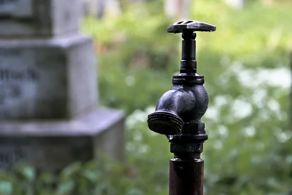 Tekoucí vodou a kohoutek na hřbitově — Stock fotografie