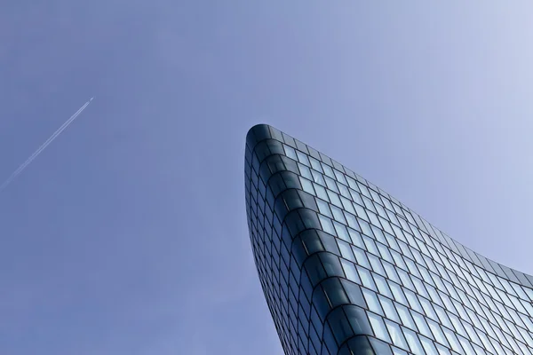 Flugzeug passiert ein modernes Gebäude — Stockfoto