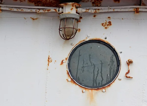 Портовая дыра и свет на старом ржавом корабле — стоковое фото
