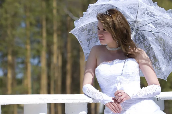Making look younger bride with umbrella — Stock Photo, Image