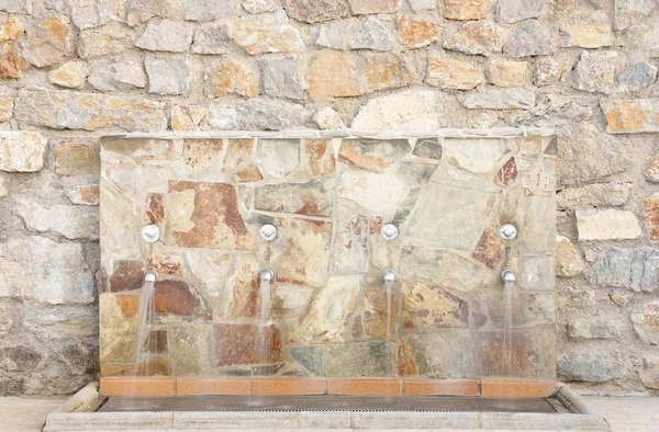 Wasserquelle in Mauer aus Stein — Stockfoto