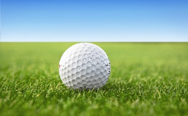 White golf ball on a green golf course clipart