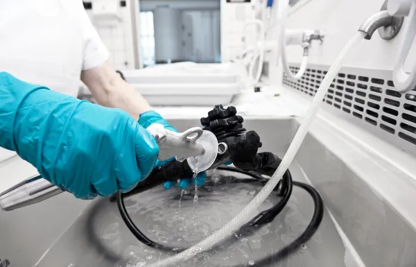 Hand mit Handschuh reinigt Krankenhausausrüstung — Stockfoto