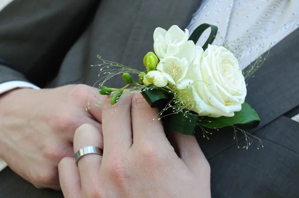Čeledín ve svatebních šatech drží Bílá růže — Stock fotografie