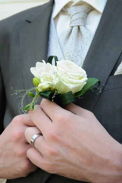 Sposo in un abito da sposa con una rosa bianca — Foto Stock
