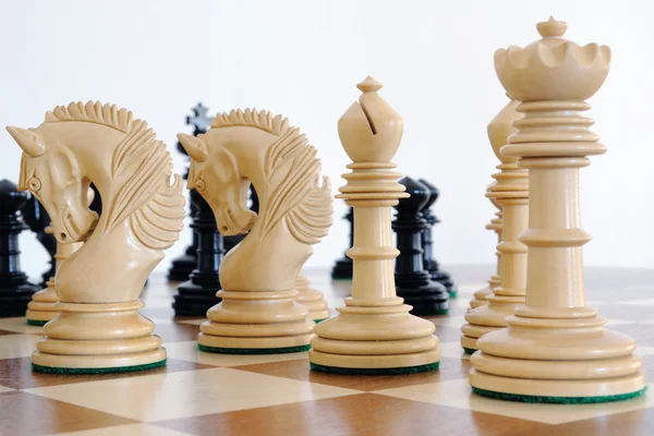 Šachové figurky na dřevěné desce — Stock fotografie