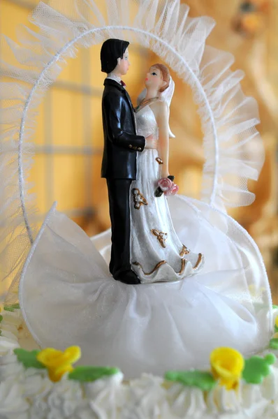 Beeldjes van de bruid en bruidegom op de taart — Stockfoto